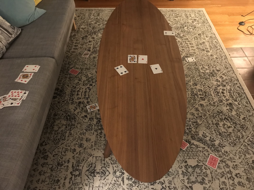 Picture of a coffee table with playing cards on and around it.